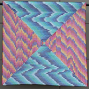 A colorful modern quilt with one-quarter inch alternating warm and cool sides of a courthouse steps single block.
