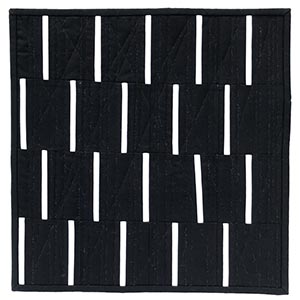 A modern mini quilt with white vertical bars on a black background.